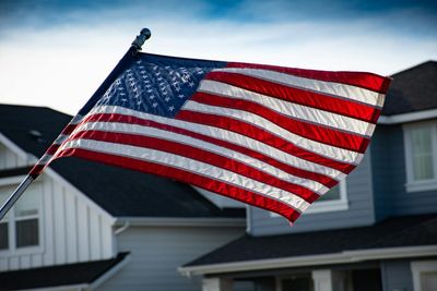 American flag waving in front of houses